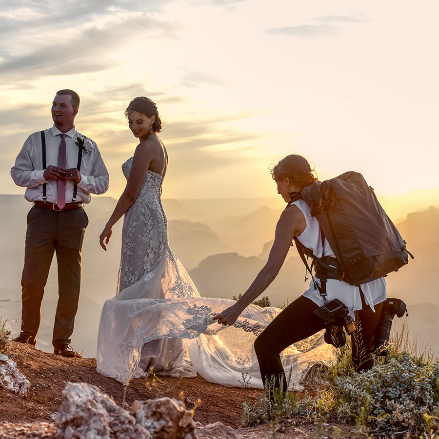 grand canyon wedding photographer helping bride with wedding dress working