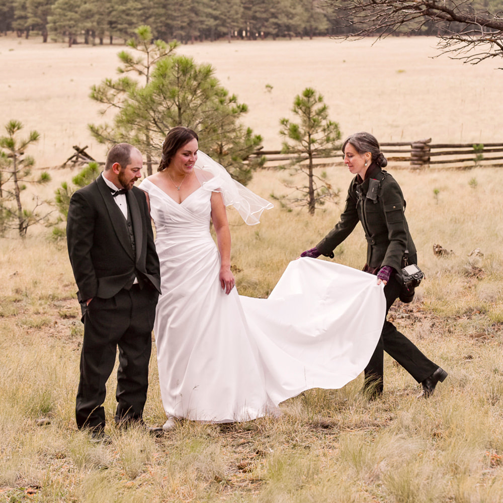 flagstaff wedding photographer helping bride with dress